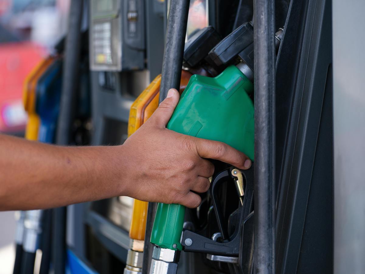 a person's hand holding a gas pump