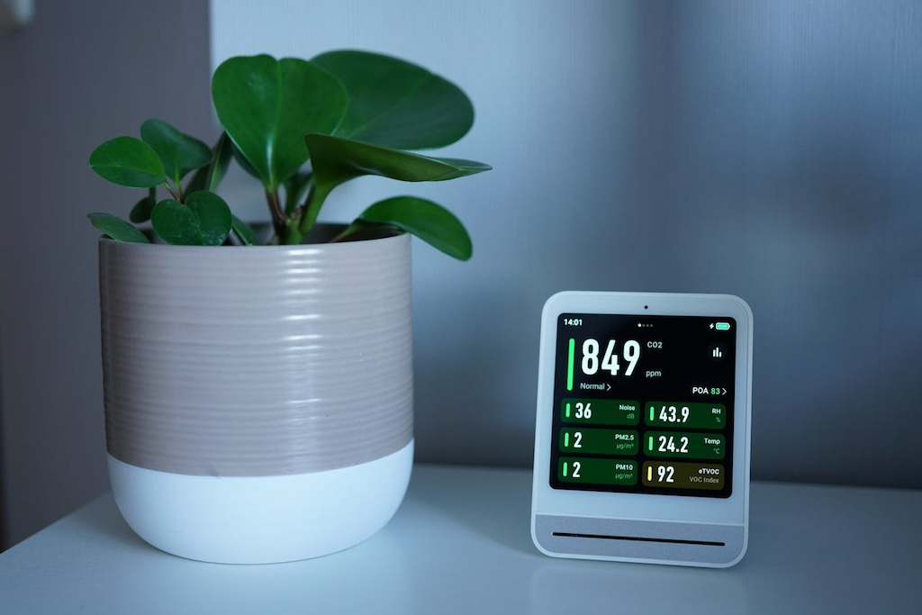 modern-air-quality-monitor-beside-indoor-plant modern air quality monitor beside indoor plant on the table