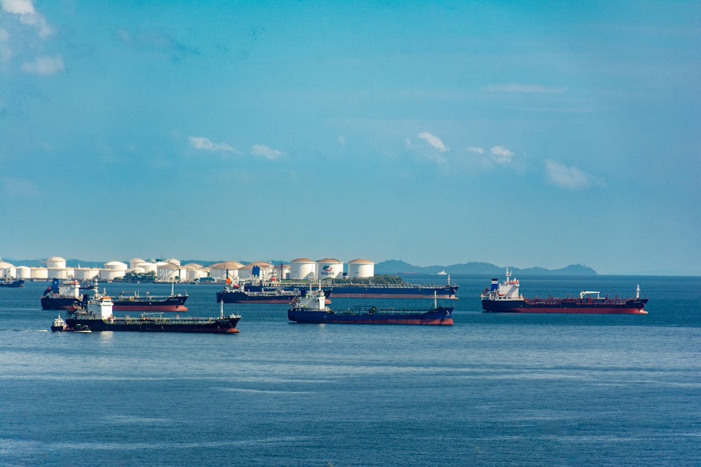cargo ships anchored at coastal port under blue sky