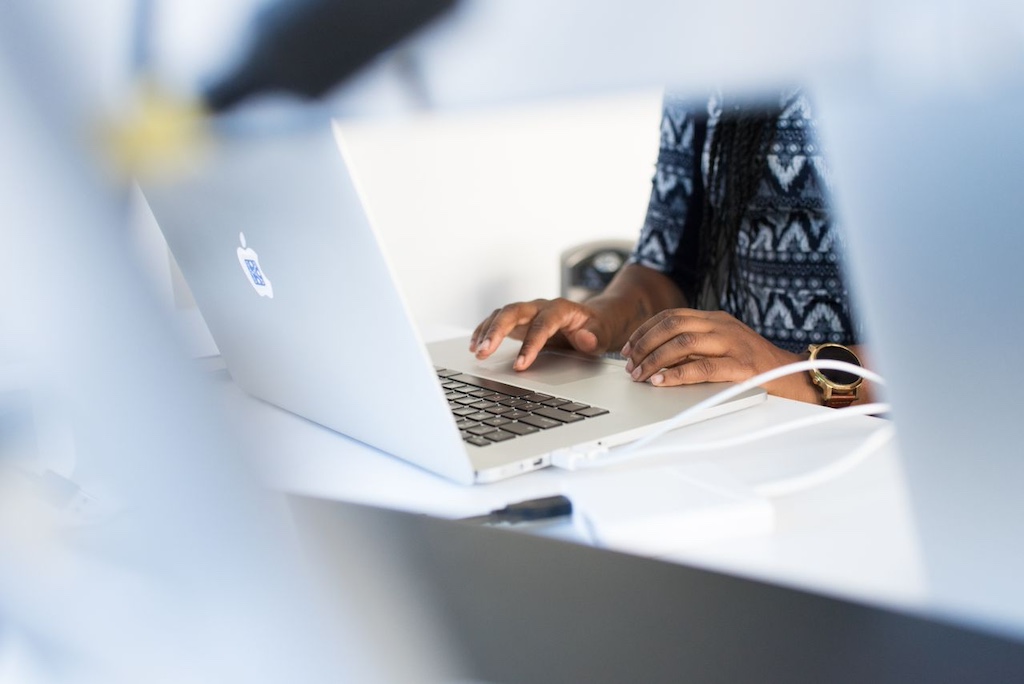 person-in-front-of-table-using-macbook person in front of table using macbook