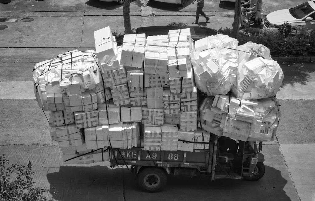 vehicles loaded with boxes in town