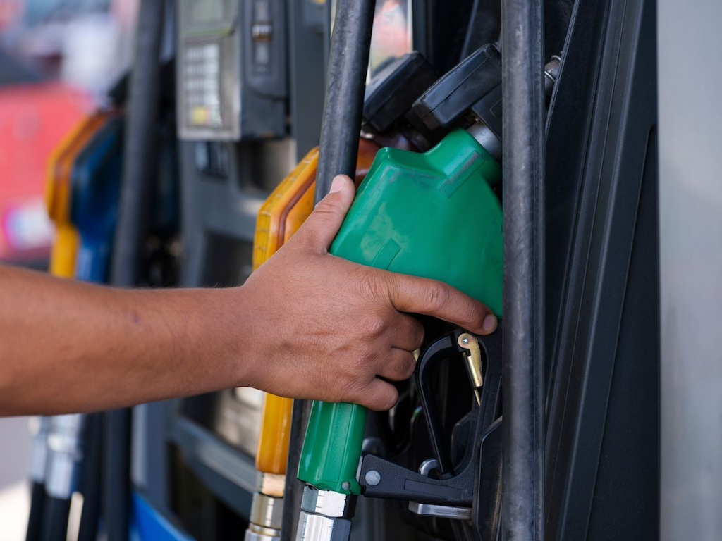 a-person-holding-a-gas-pump a person's hand holding a gas pump